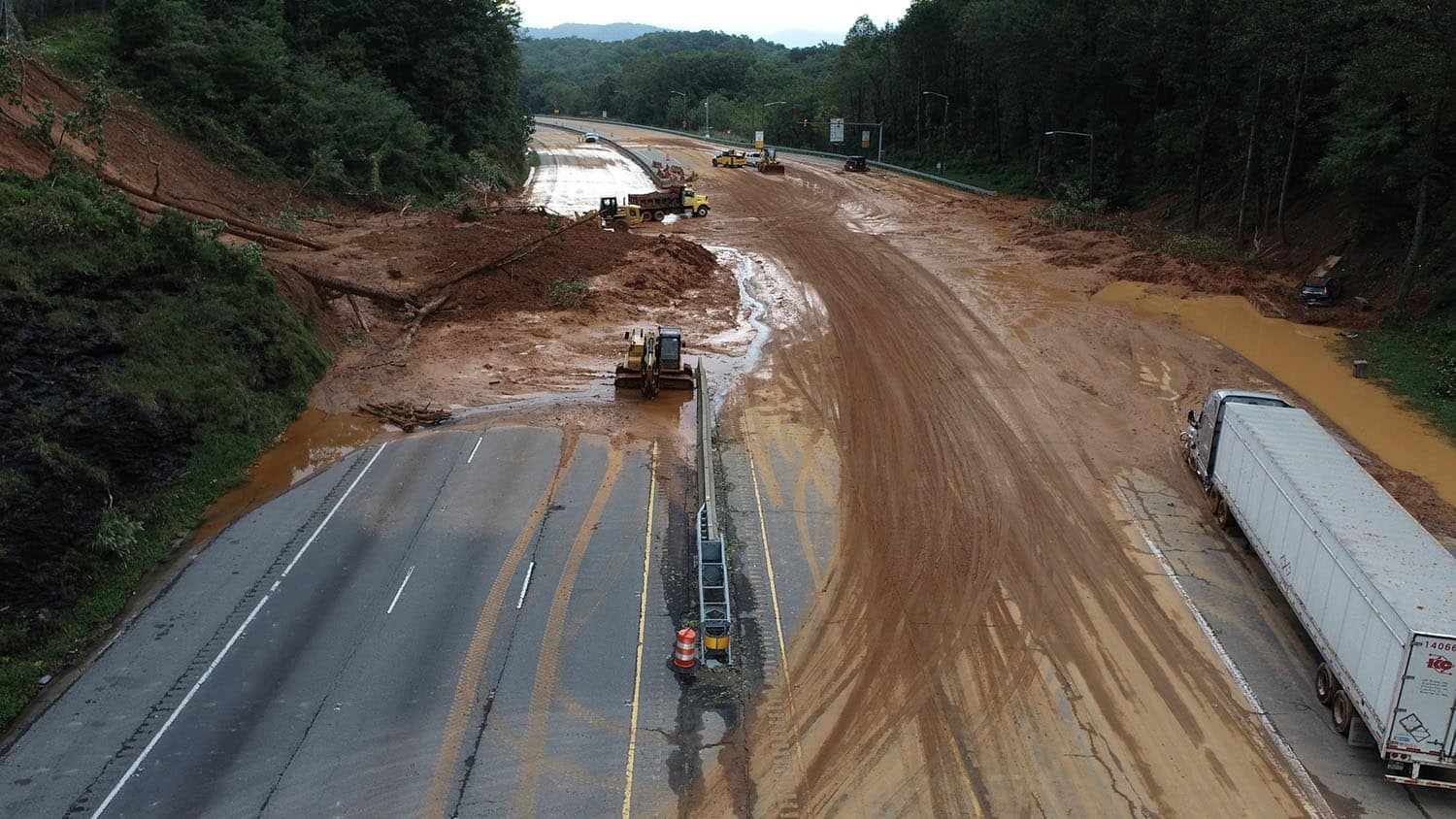 A multi-lane highway is blocked with mud and debris